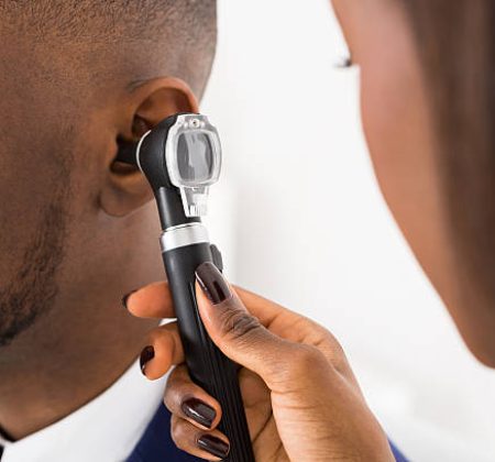 Close-up Of Doctor Examining Male Patient's Ears